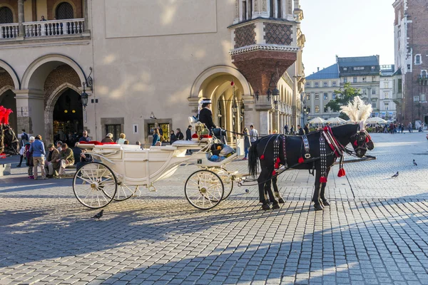 Carruajes de caballos frente a la iglesia Mariacki en la plaza principal de Kr —  Fotos de Stock