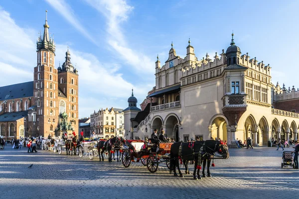 Horse carriages in front of Mariacki church on main square of Kr — Stock Photo, Image