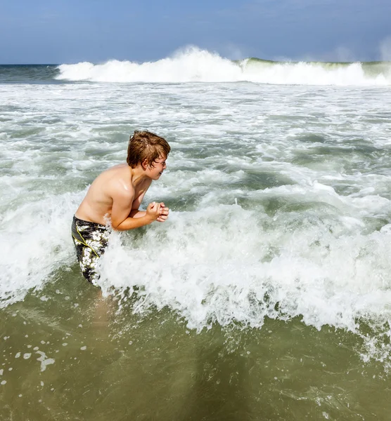 Boy enjoys the waves of the sea Stock Picture