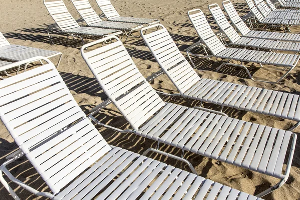 Muchos salones y sombrillas en la playa — Foto de Stock