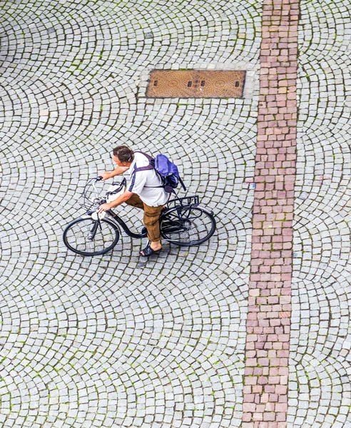 Uomo attraversa la piazza del mercato presso la cattedrale con la sua bicicletta — Foto Stock