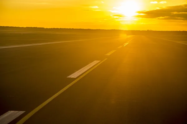 Zonsondergang met reflecties op de start-en landingsbaan — Stockfoto