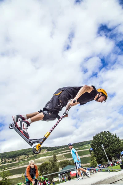 Teen jumps with scooter over a ramp and performs a salto — Stock Photo, Image