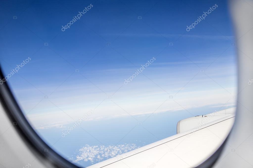 aerial out of an aircraft window with clouds and landscape