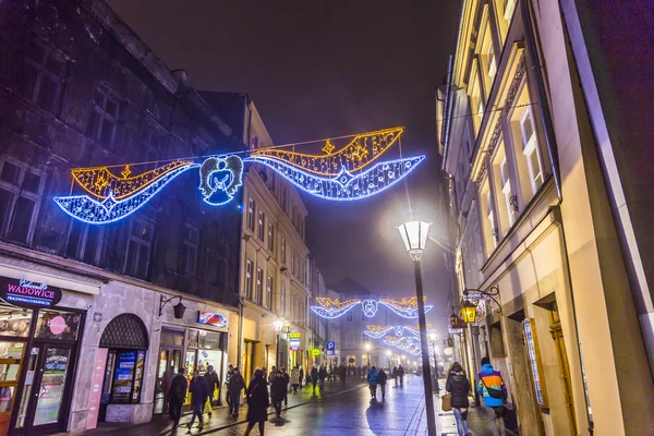 La gente visita el mercado de Navidad en Cracovia, Polonia por la noche — Foto de Stock