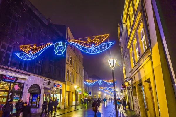 La gente visita el mercado de Navidad en Cracovia, Polonia por la noche —  Fotos de Stock