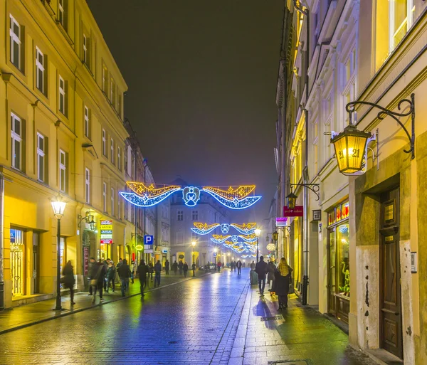Люди посещают Рождественский рынок в Кракове, Польша ночью — стоковое фото