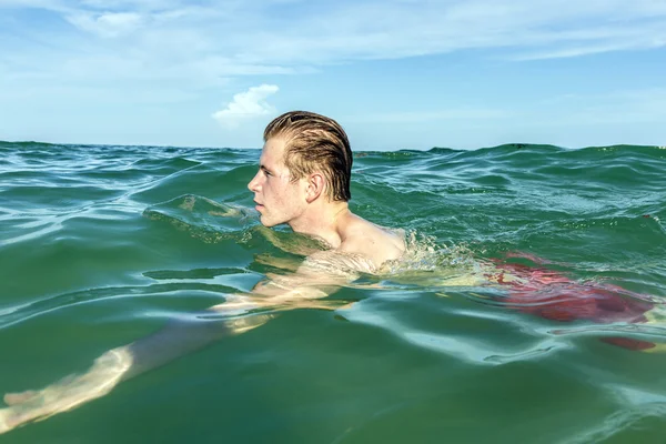 Dospívající chlapec má plavání v oceánu — Stock fotografie