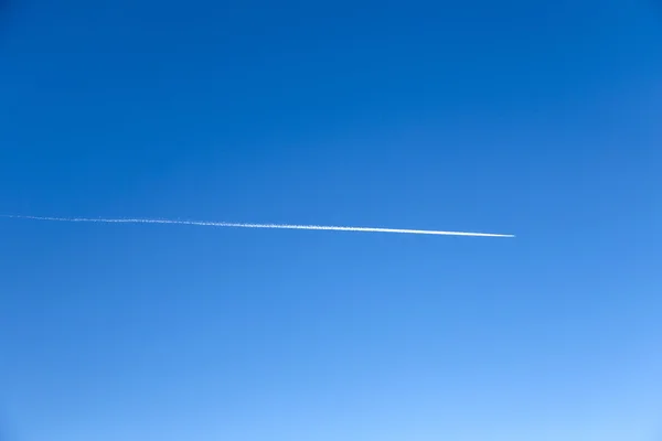 蒸気道と完全に青い空に飛んでいる飛行機 — ストック写真