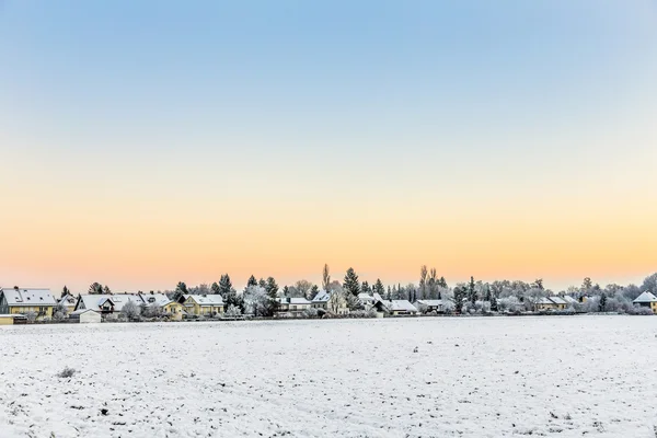 Campos cobertos de neve com assentamento no horizonte em Munique — Fotografia de Stock