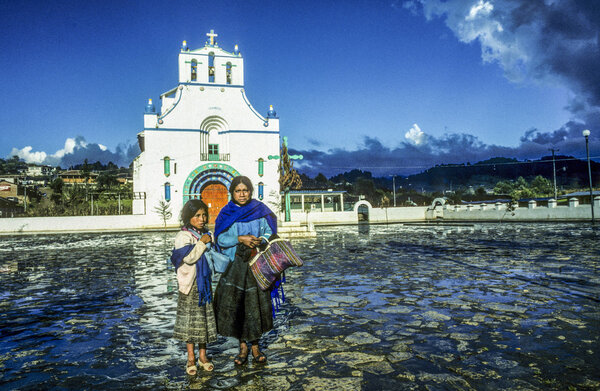 Мать с ребенком продает сувениры ручной работы в церкви Сан-Хуан
