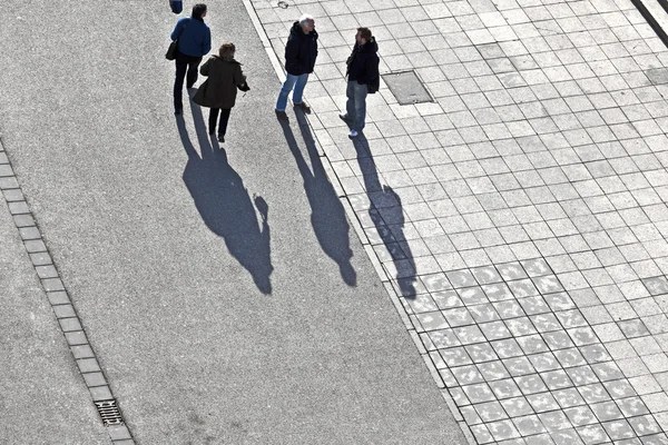 Gente caminando por la calle con largas sombras —  Fotos de Stock