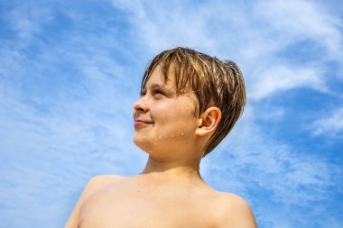 mutlu kahverengi saçlı genç çocuk plaja sahiptir