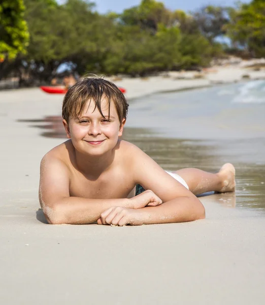 Chłopiec znajduje się przy piaszczystej plaży i szczyci się ciepłym piasku — Zdjęcie stockowe