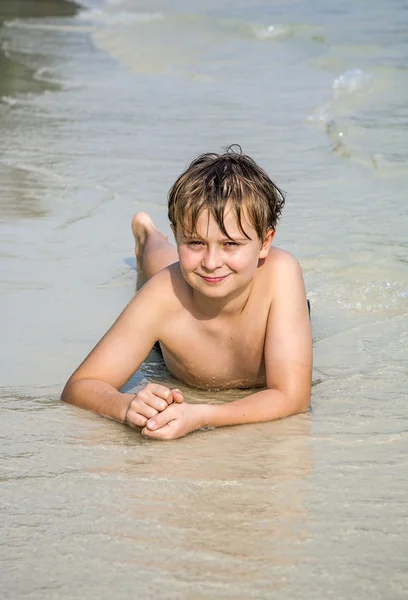 소년 모래 해변에 고 운 따뜻한 모래를 즐긴다 — 스톡 사진