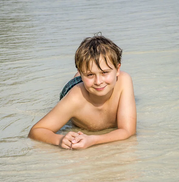 少年は、砂浜のビーチであるし、暖かい砂浜を楽しんでいます — ストック写真