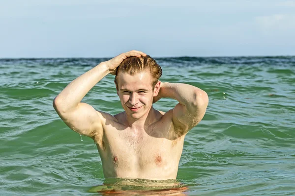 Teenage boy enjoys swimming in the ocean — Stock Photo, Image