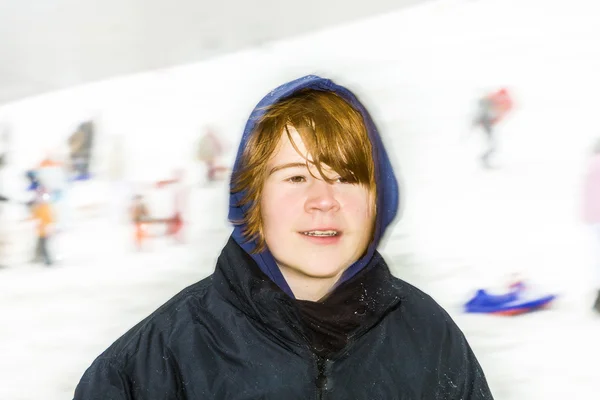 Jongen kijkt blij uit het spelen in de sneeuw — Stockfoto