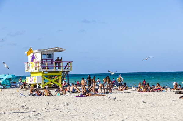 people walk along the promenade at ocean drive