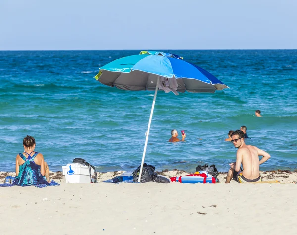 People enjoy the afternoon sun at South Beach in Miami — Stock Photo, Image