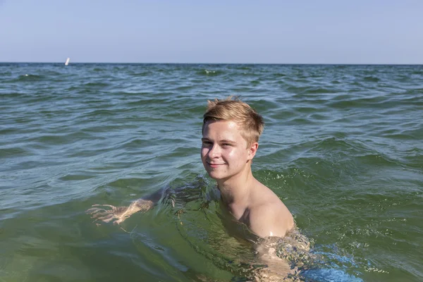 Vacker tonåring har kul simning i havet — Stockfoto