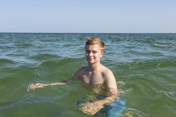 Bonito adolescente se diverte nadando no oceano — Fotografia de Stock