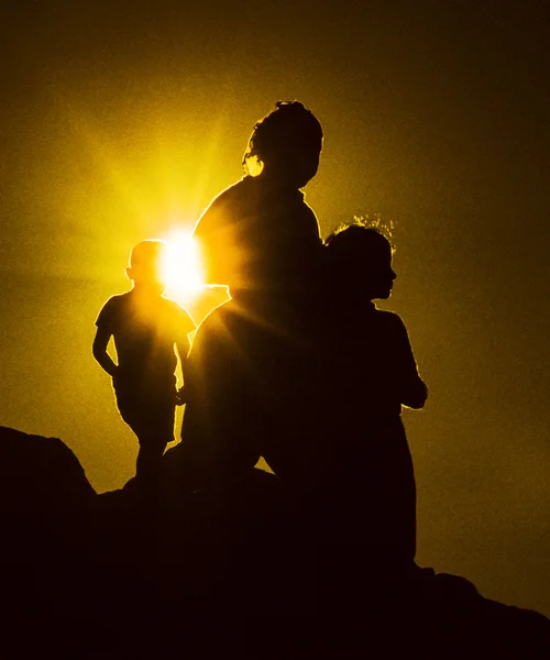 Familie geniet van de zonsondergang op een heuvel — Stockfoto