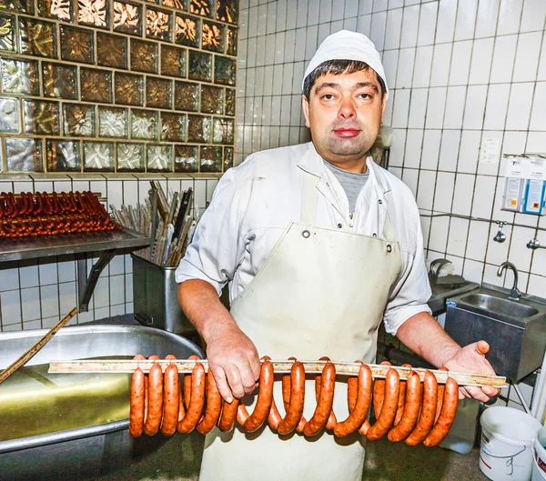 Butcher prepares fresh sausage — Stock Photo, Image