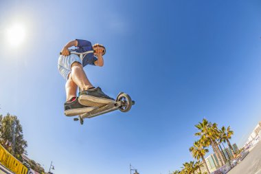 çocuk onun scooter ile bir rampa atlar.