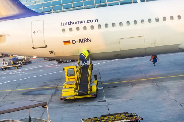Arbetaren laddar last till flygplan i Frankfurt — Stockfoto