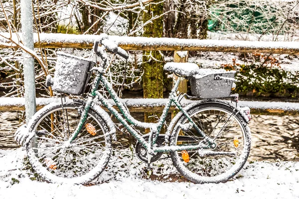 Bicicleta codificada por nieve apoyada en una barandilla —  Fotos de Stock