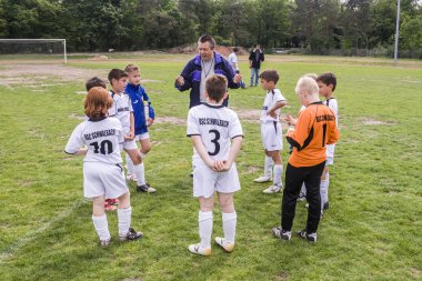 eğitmen genç oyuncular ile futbol maç tartışıyor