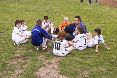 eğitmen genç oyuncular ile futbol maç tartışıyor