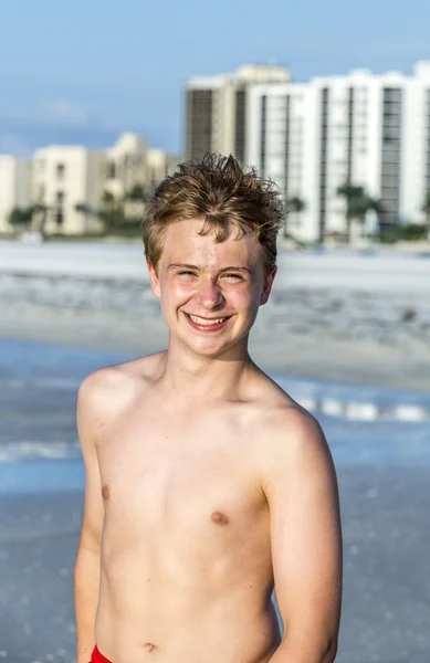 Knappe vertrouwen tiener in de zonsondergang op het strand — Stockfoto