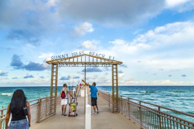 insanlar Sunny Isles Beach balıkçılık iskele tadını çıkarın.