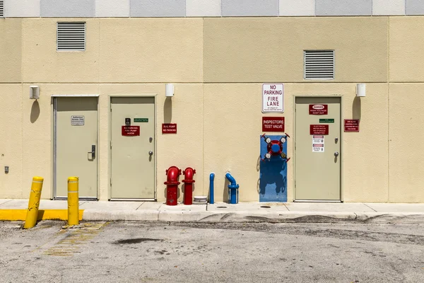 Пожарный гидрант и аварийный выход на задней стенке — стоковое фото