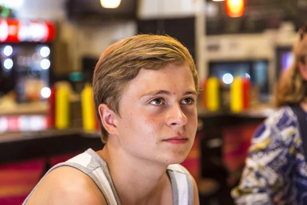 Junge im Restaurant studiert Speisekarte an der Wand — Stockfoto