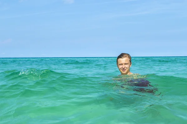 Bello giovanissima has divertimento swimming in il ocean — Foto Stock