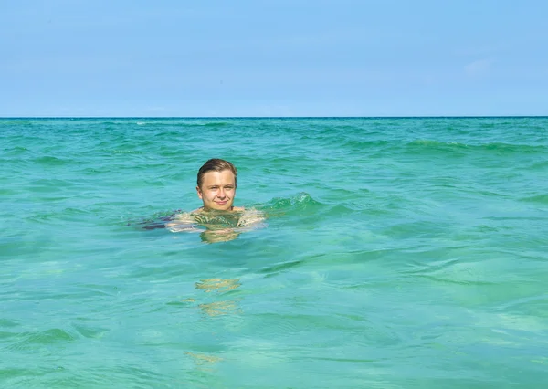 Knappe tiener heeft leuke zwemmen in de Oceaan — Stockfoto