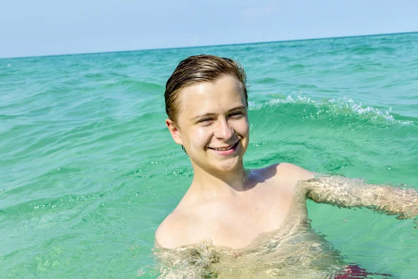 Schöner Teenager hat Spaß beim Schwimmen im Ozean — Stockfoto