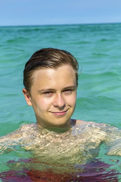 Knappe tiener heeft leuke zwemmen in de Oceaan — Stockfoto