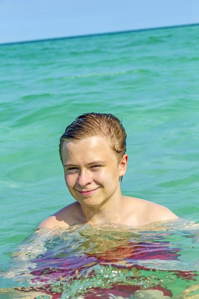 Bonito adolescente se diverte nadando no oceano — Fotografia de Stock