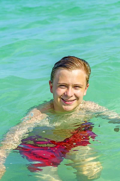 Hermoso adolescente se divierte nadando en el océano —  Fotos de Stock