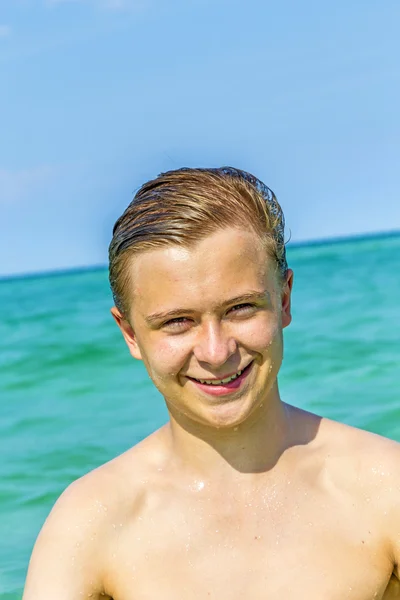 Knappe tiener heeft plezier op het strand — Stockfoto