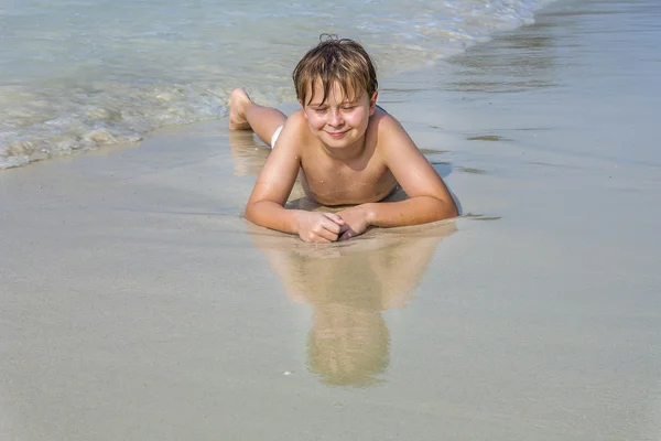 Menino na praia gosta da praia arenosa — Fotografia de Stock