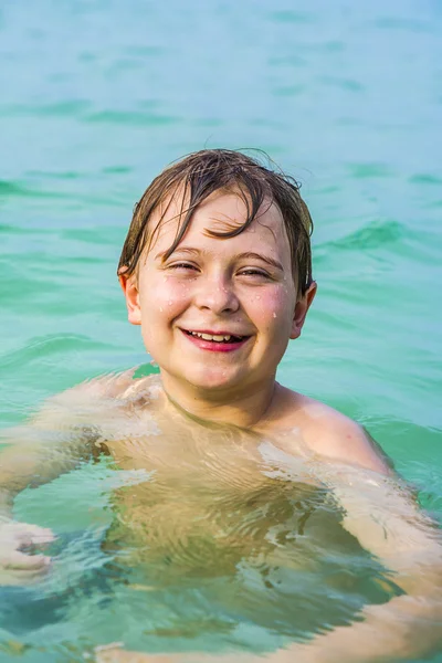 kahverengi saçlı genç çocuk yüzme sahiptir