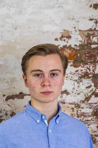 Bonito adolescente menino na frente de grungy tijolo parede — Fotografia de Stock