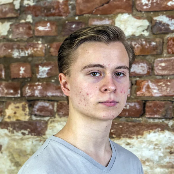 Cute teenage boy in front of grungy brick wall — Stock Photo, Image