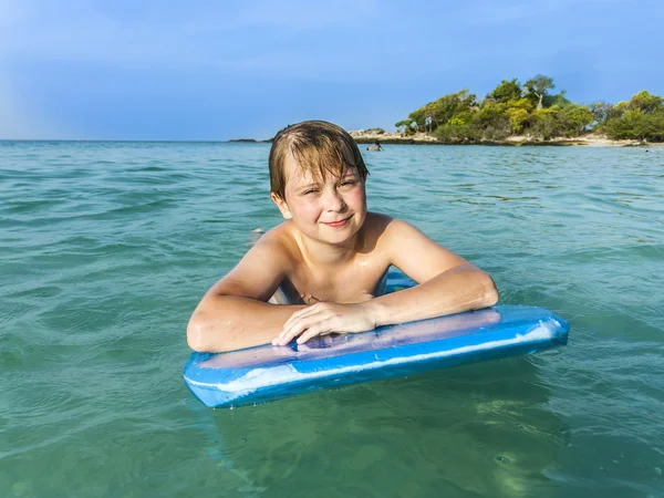 Garçon nage sur sa planche de surf — Photo