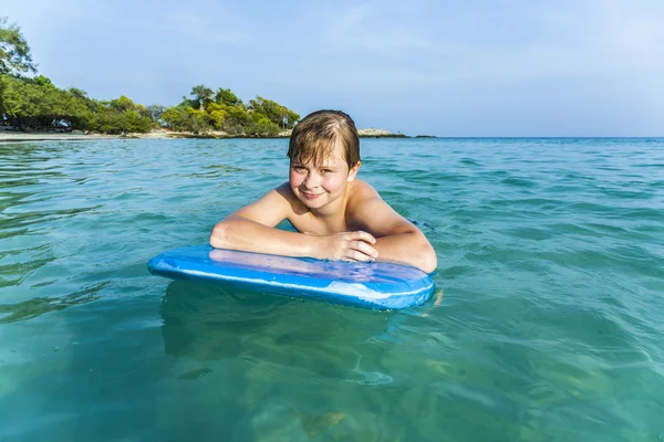 Garçon nage sur sa planche de surf — Photo